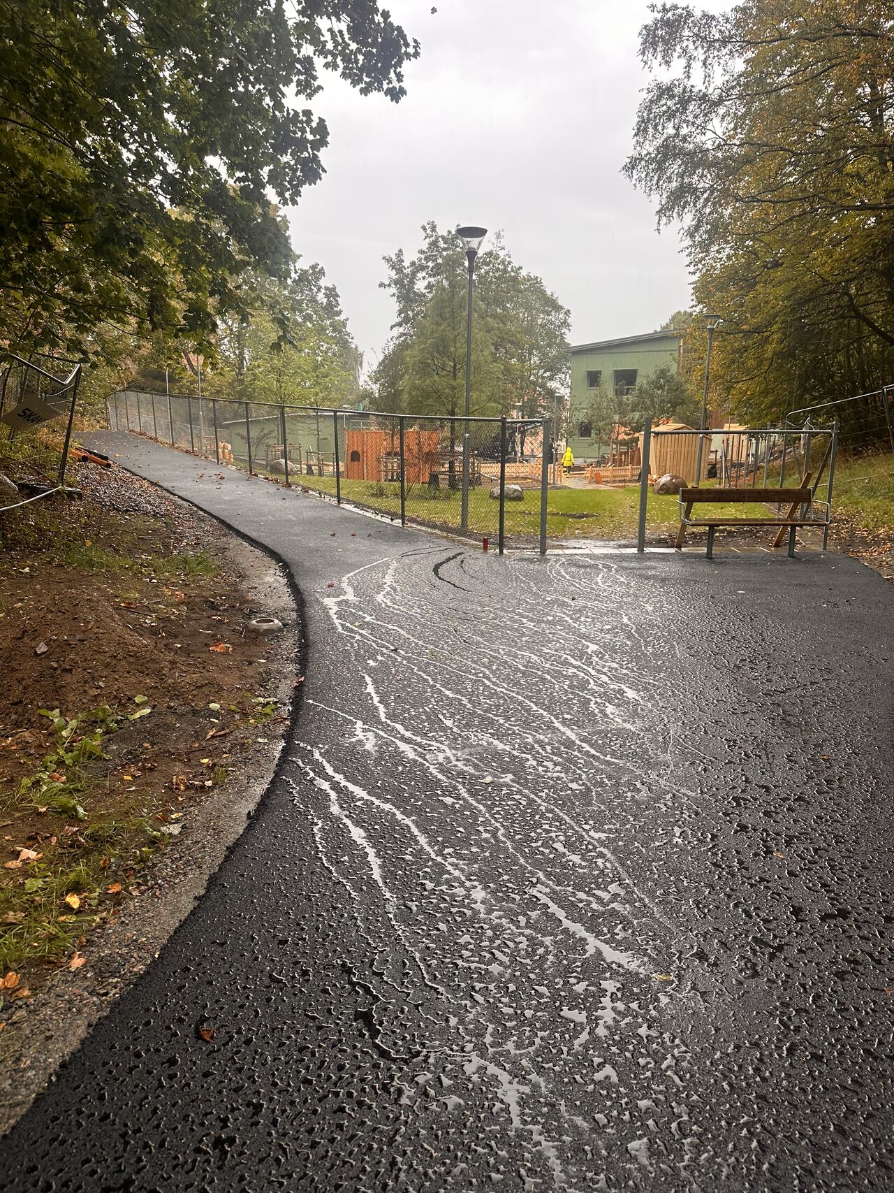 Nyasfalterad gångväg intill förskola i regn, Göteborg